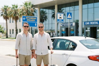 Couple souriant à l'aéroport d'Héraklion avec valises