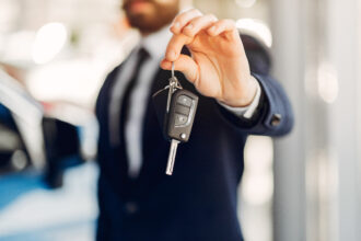 un homme montrant une clé de voiture