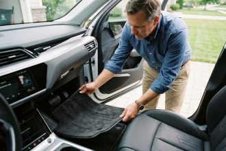 Homme d'affaires installant un tapis de voiture dans un SUV moderne
