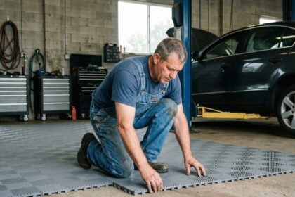 Mécanicien posant des carreaux dans un garage spacieux
